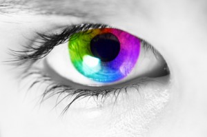 Macro of a human eye with spectrum colors in the iris looking at camera. Picture converted to black and white except for the iris.