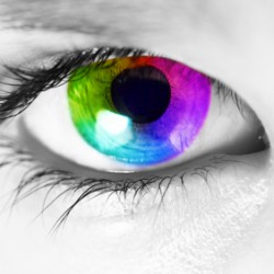 Macro of a human eye with spectrum colors in the iris looking at camera. Picture converted to black and white except for the iris.